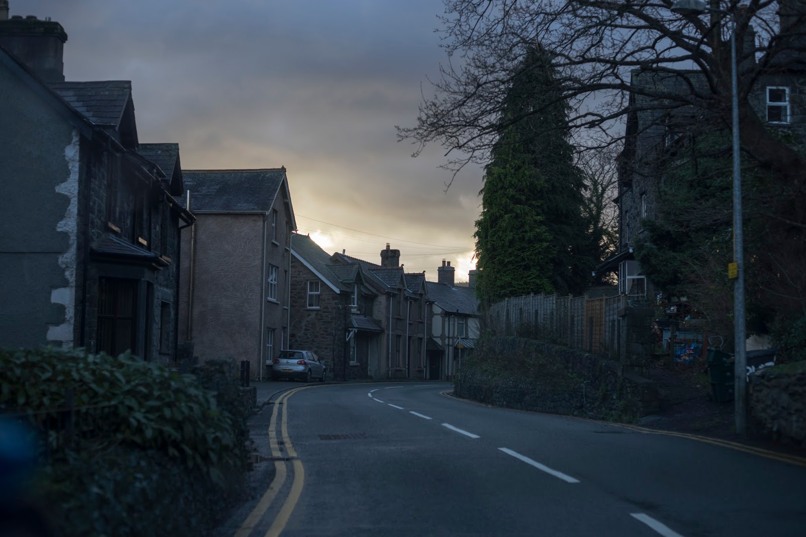 a street at dusk with the sun shining