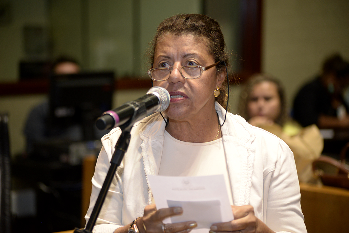 woman speaking in front of a microphone in a courtroom