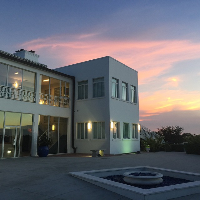 this modern house has a fountain in the driveway