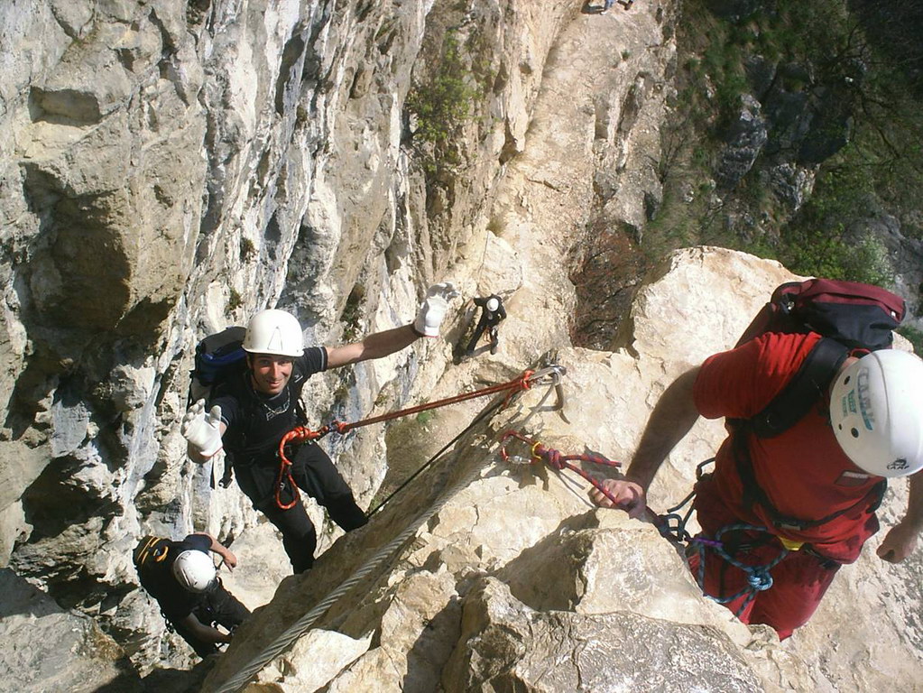 some people holding onto ropes on a rock face