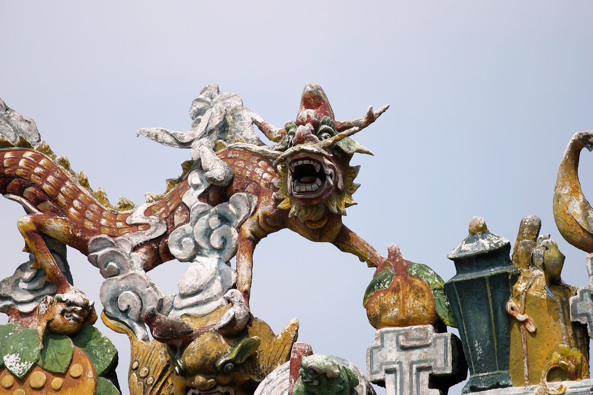 a statue of dragon like creature is near a church