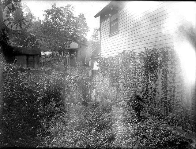 an old po of a house and clock in the back yard