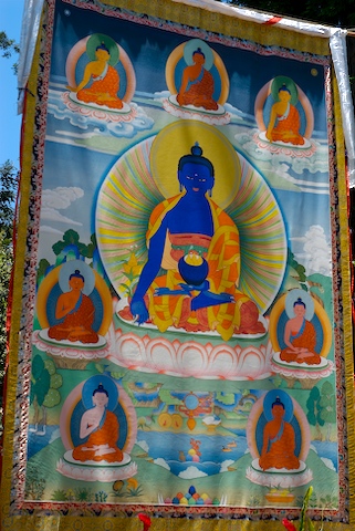 a tapestry hanging on a wall that is covered in buddhist buddha pictures