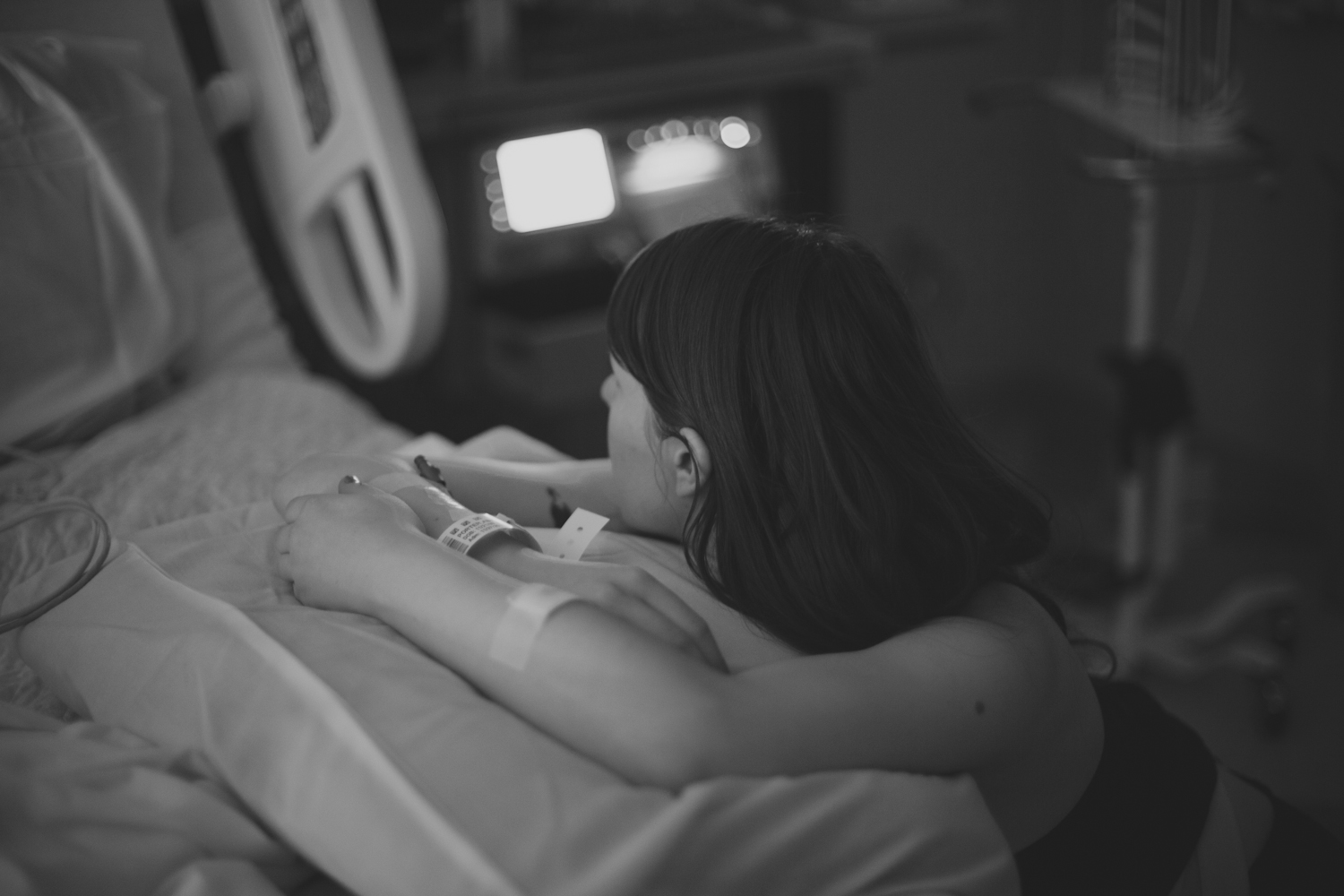 black and white pograph of woman lying in a hospital bed