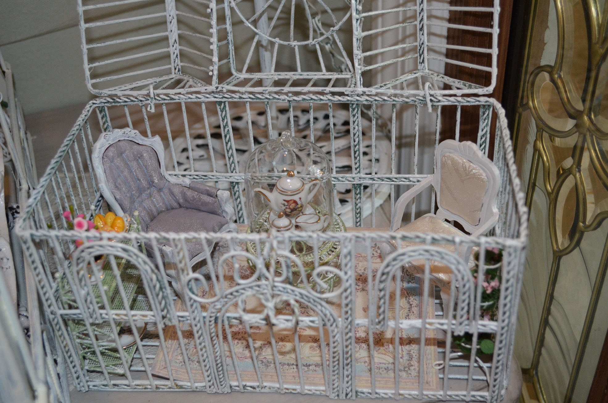 a white cage sitting in front of a mirror