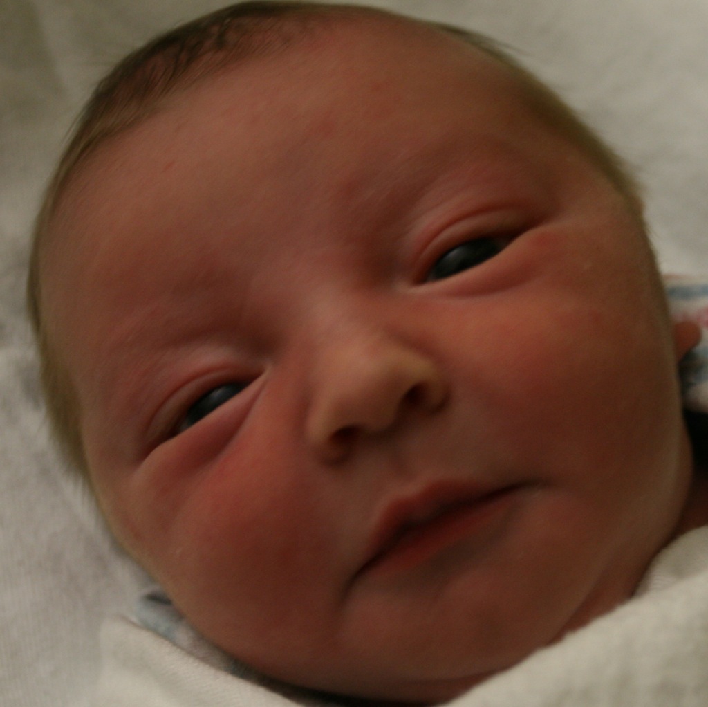 a baby laying in a bed looking straight ahead