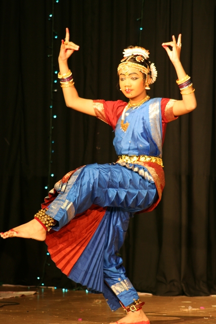 the dancer is dressed in a blue, orange and red costume