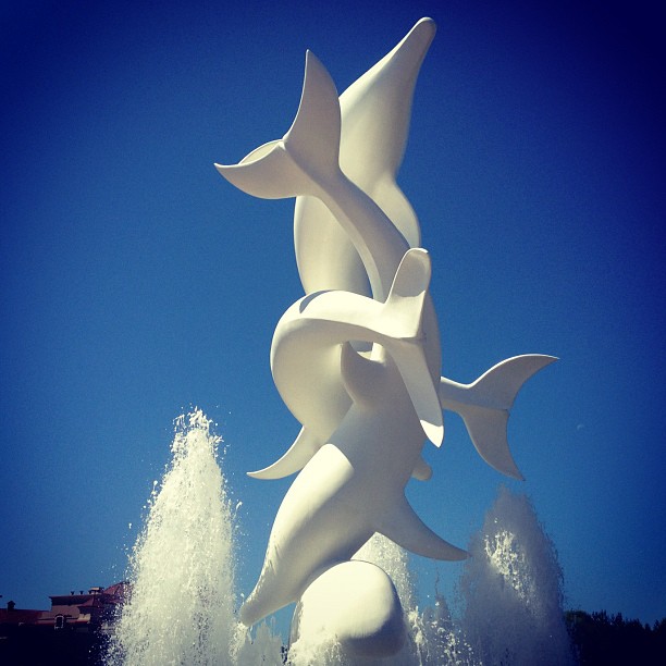 the sculpture is situated in front of some water