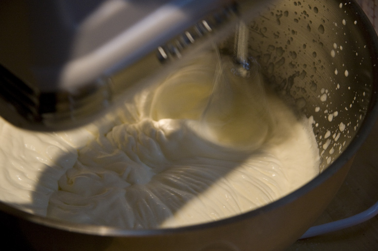 cream being whipped in a mixer with a mixer handle