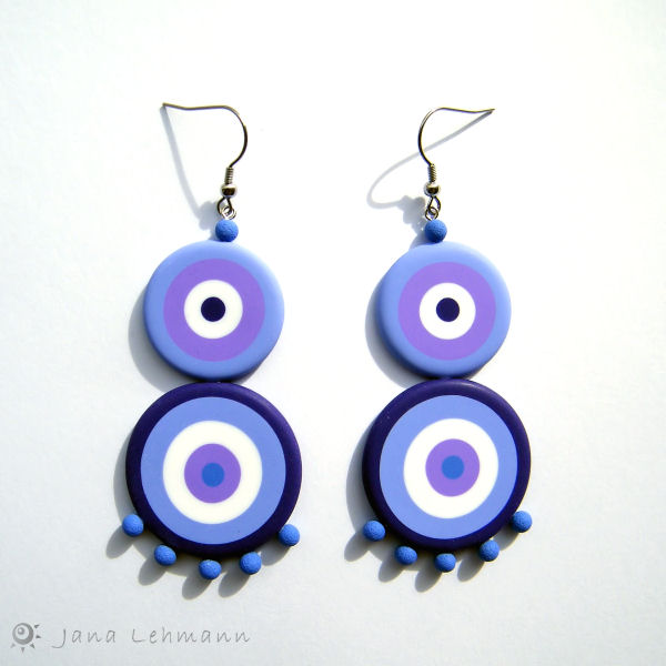 the earrings are blue and white with purple circles