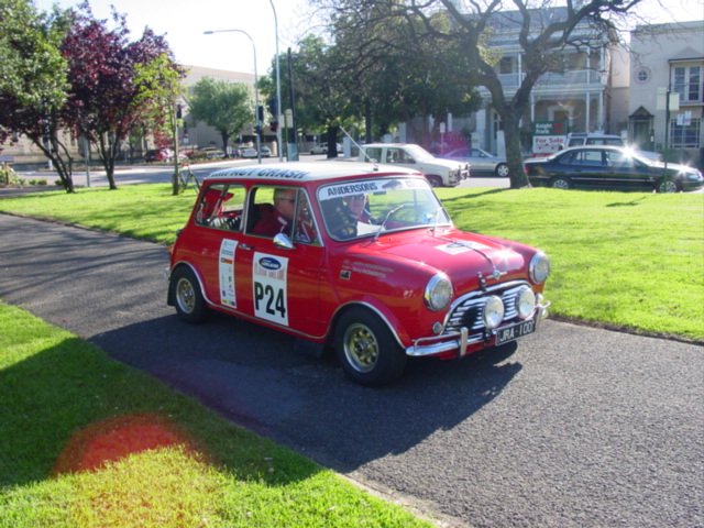 an old red and white car parked at a park