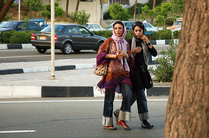 a couple of women walk down the street