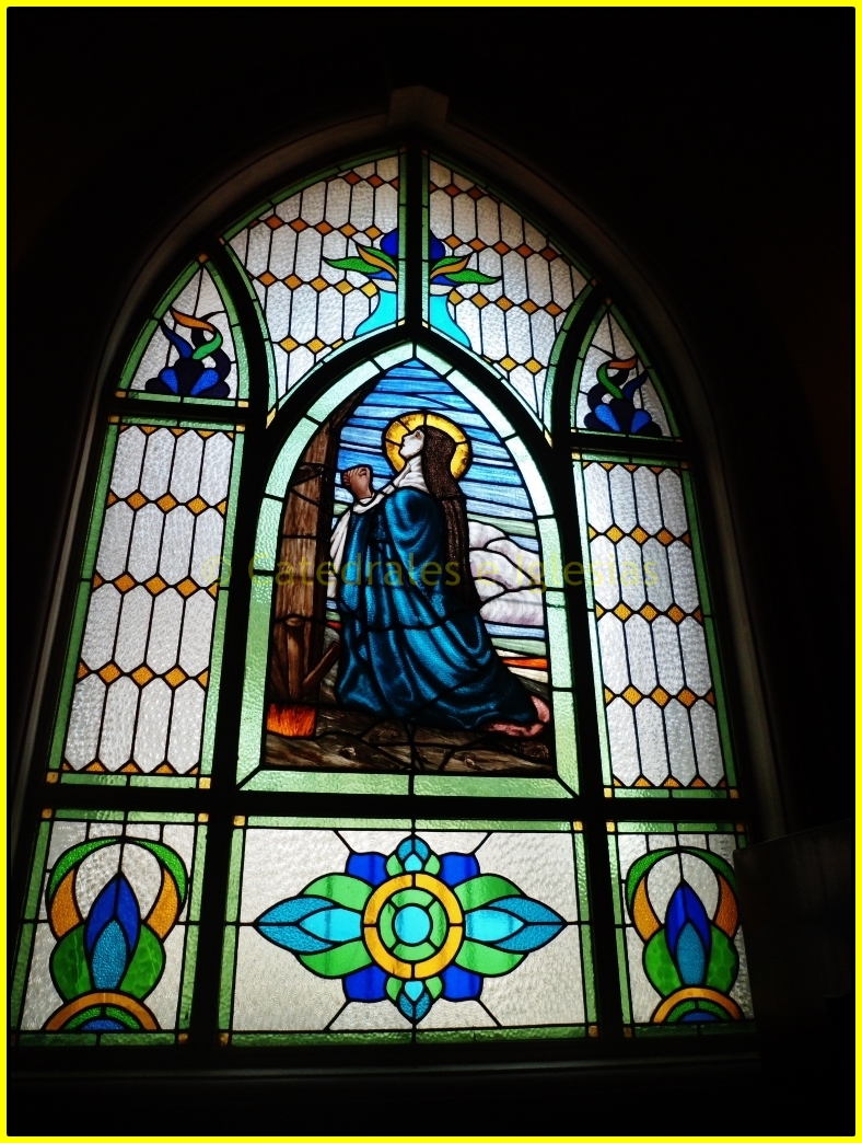 an ornate stained glass window with lady in blue