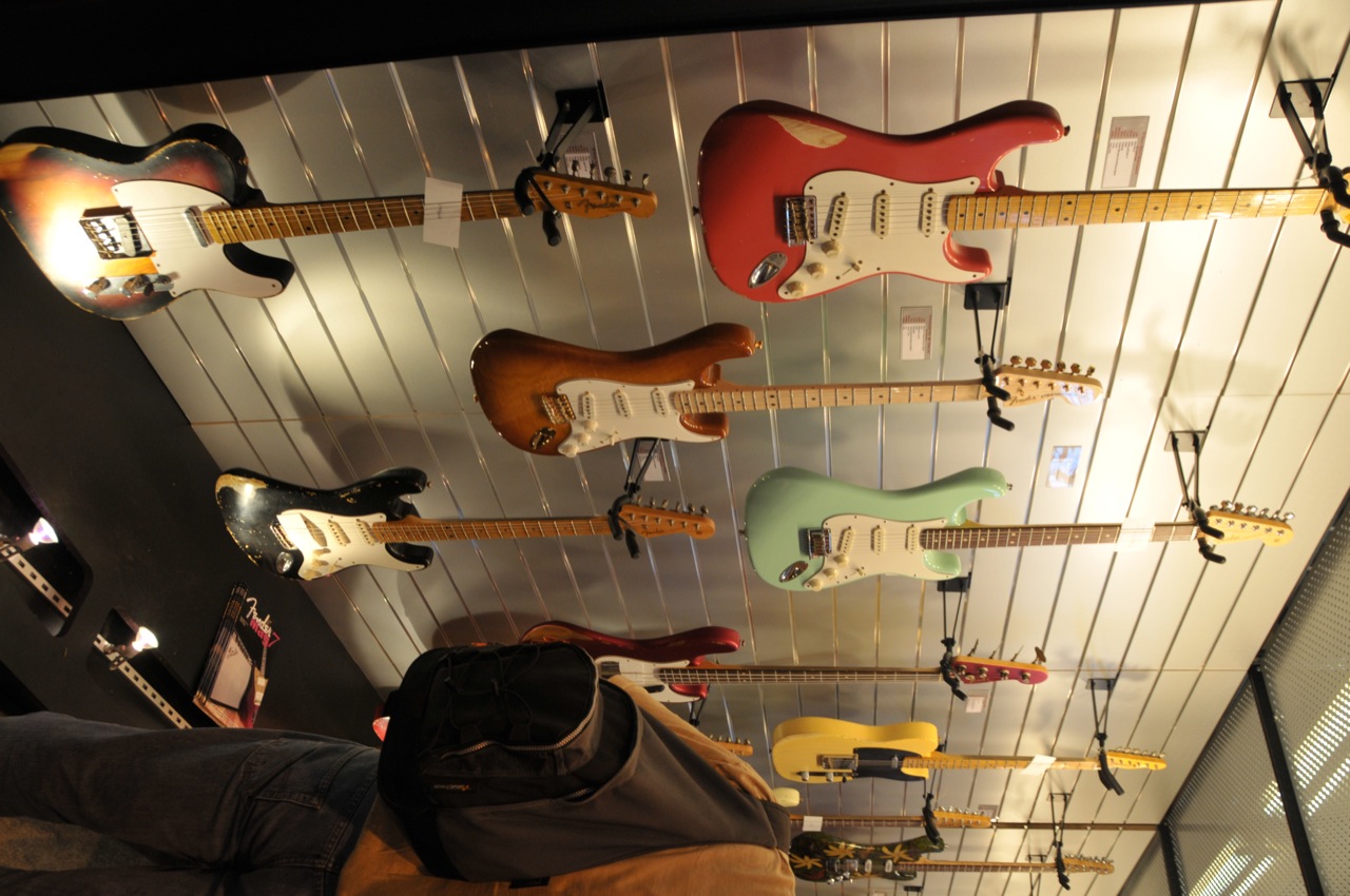 many guitars are lined up in a display