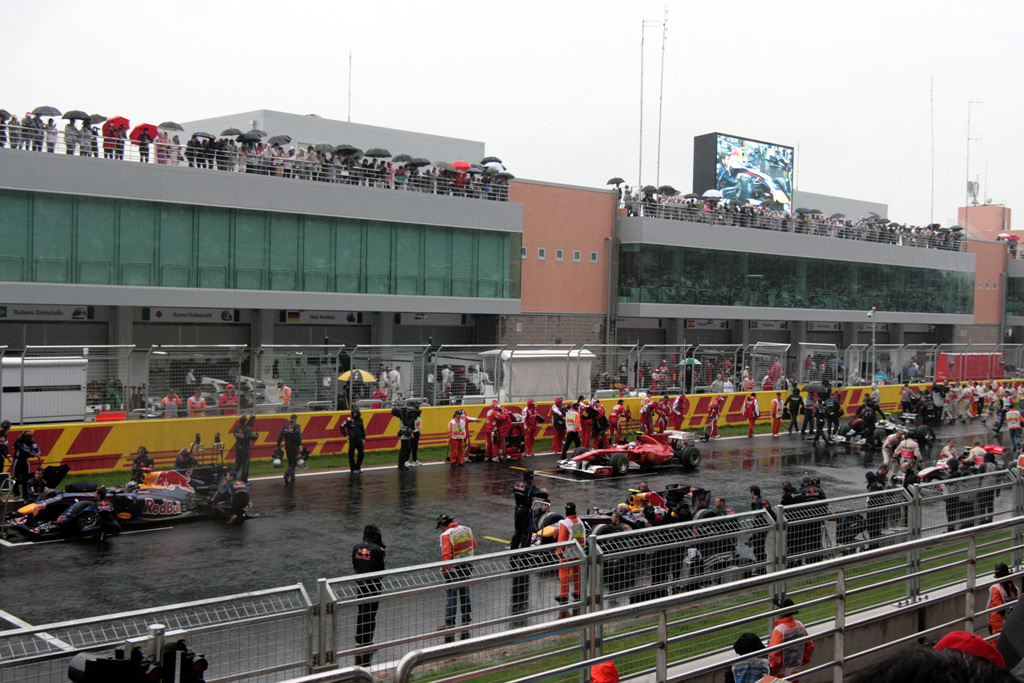 spectators watch a red bull race as the drivers are driven around the track