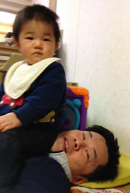 a little child is laying on the floor next to a man