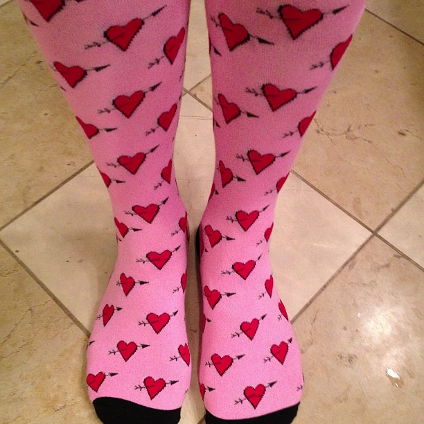 a persons legs in pink and red hearts pattern on them