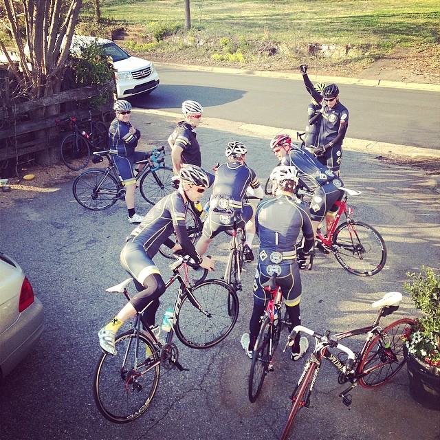 five bicyclists are lined up in the street for a ride