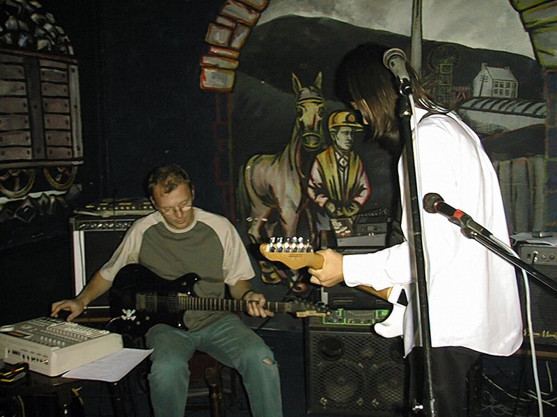 an image of man on stage with guitar and amp