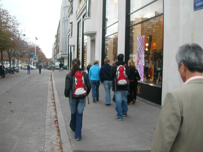 the people are walking outside in front of a store