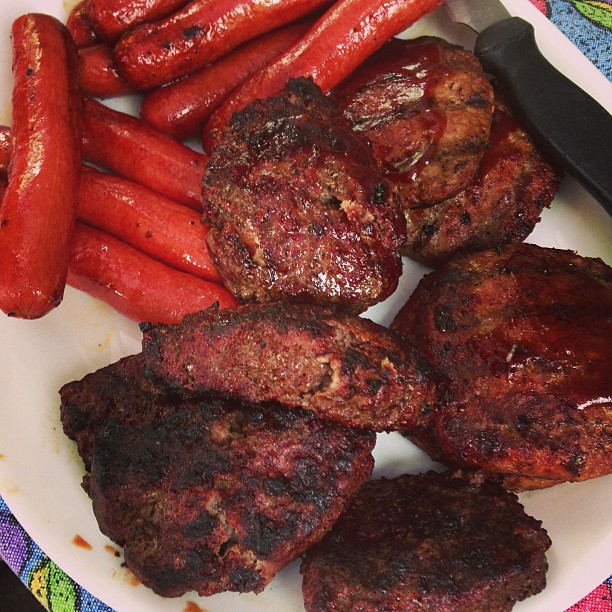 a white plate with sausages, carrots and meat