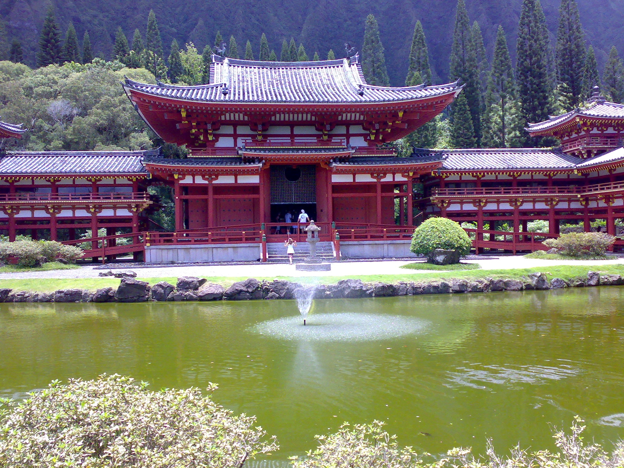 a big red pagoda in the middle of a pond