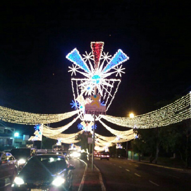 cars driving on a road decorated with lights
