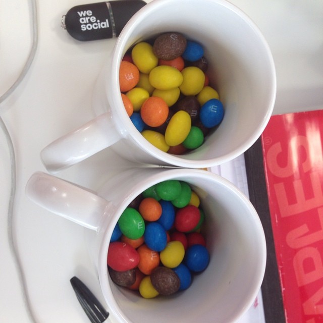 two mugs that are filled with assorted candy