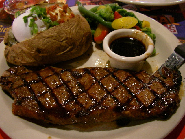 a plate of steak, a baked potato and vegetables