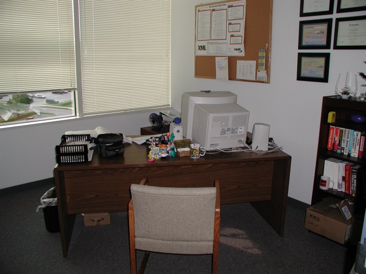 an office has two chairs, desk with computer and printer