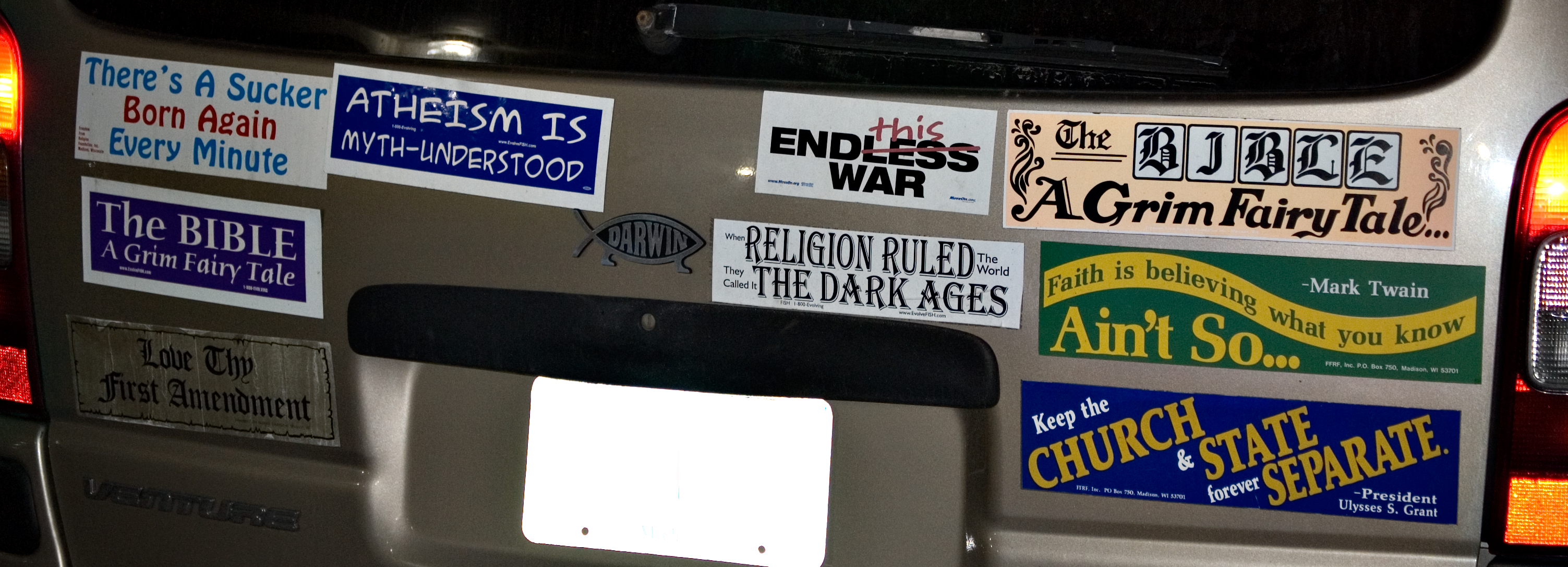 the back end of a car with bumper stickers on it