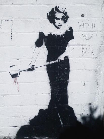 a large white painted wall with a woman in black dress holding a knife
