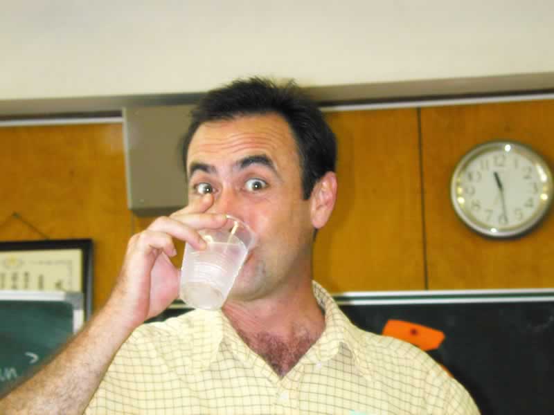 a man drinking a plastic cup from a bottle