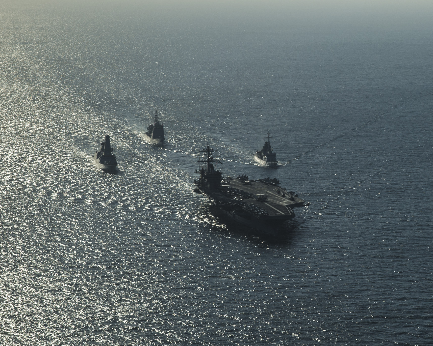 the ship are all being followed by four smaller boats