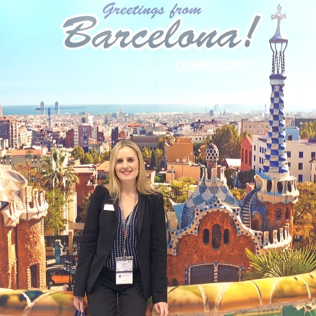 a woman standing next to a large poster in front of a city