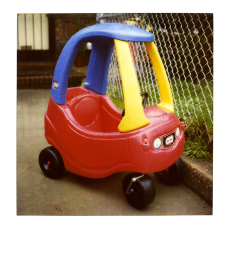 a plastic red and yellow car with its wheels