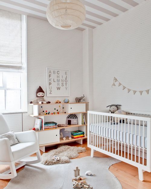 the baby room has white furniture and rugs