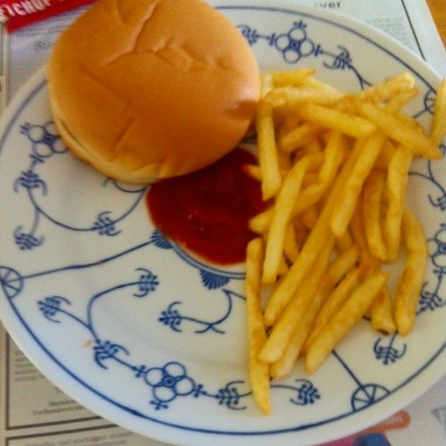 a plate of fries and a hamburger with ketchup on it