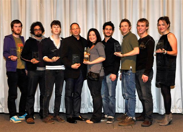 a group of people posing with awards in their hands