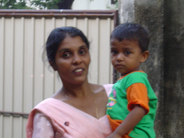 an adult carrying a child and smiling at the camera