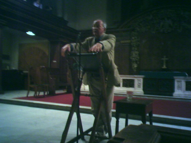 man leaning on a metal object in front of a church