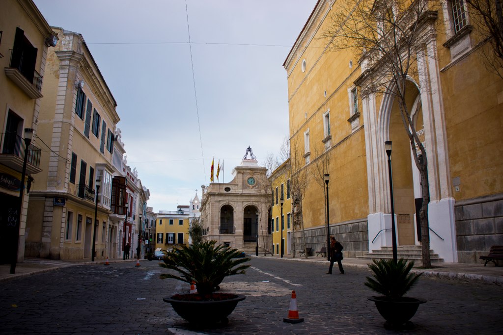 an old city street with plants in the middle