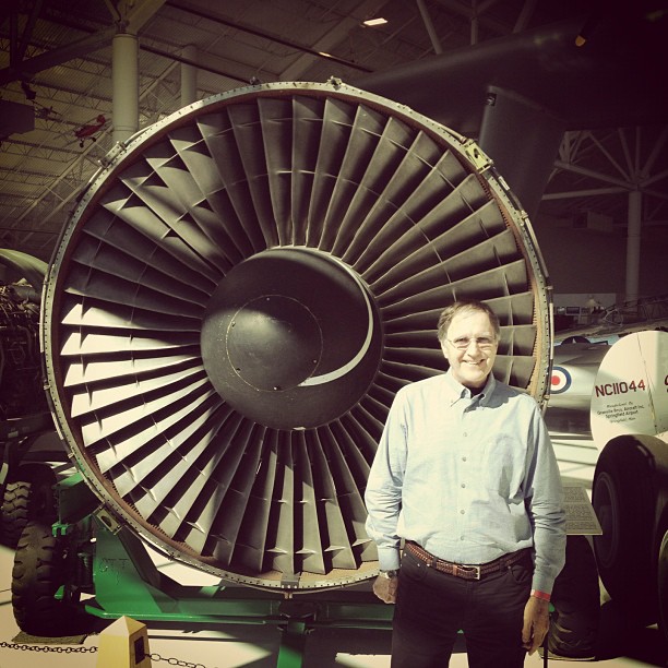 man standing in front of a large jet engine in a hanger