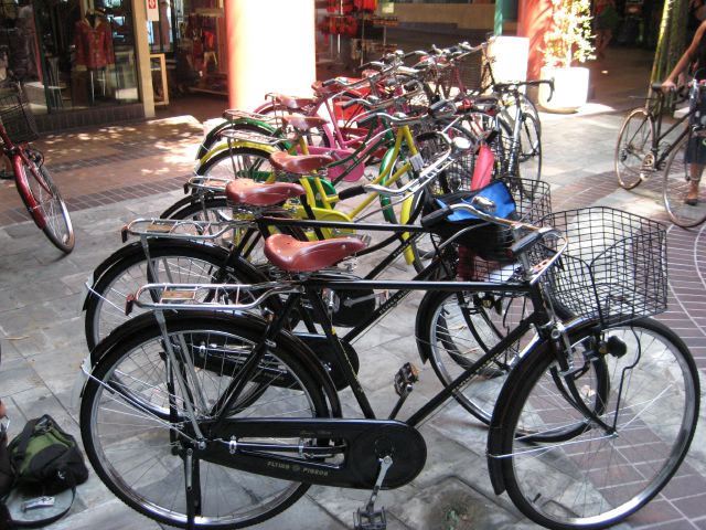 a street scene with many bicycles parked in rows