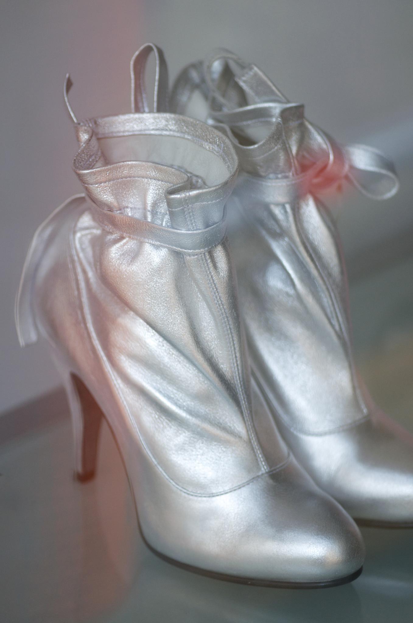 a pair of silver high heels with bow