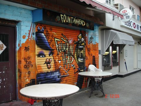 a couple of tables with chairs in front of a graffiti covered wall