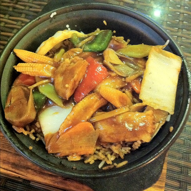 a small bowl filled with rice, chicken and veggies