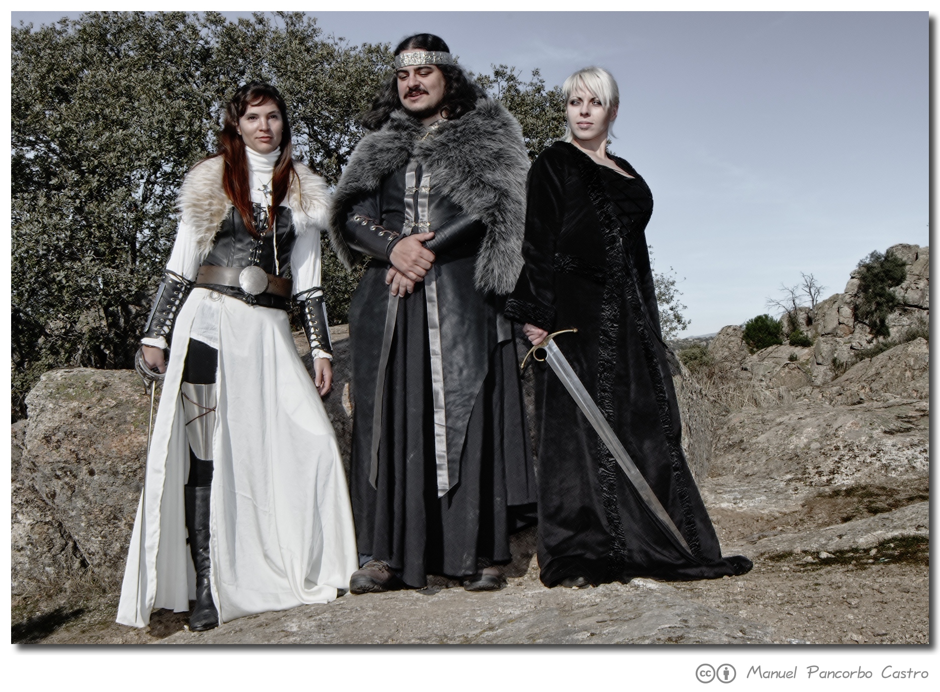 three people standing in long clothing posing for a picture