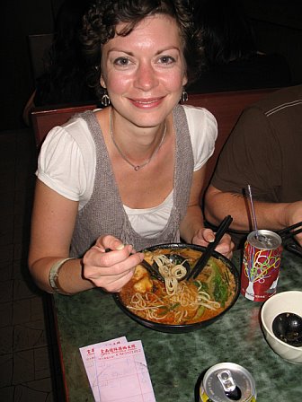a woman with a bowl of food sitting in front of her