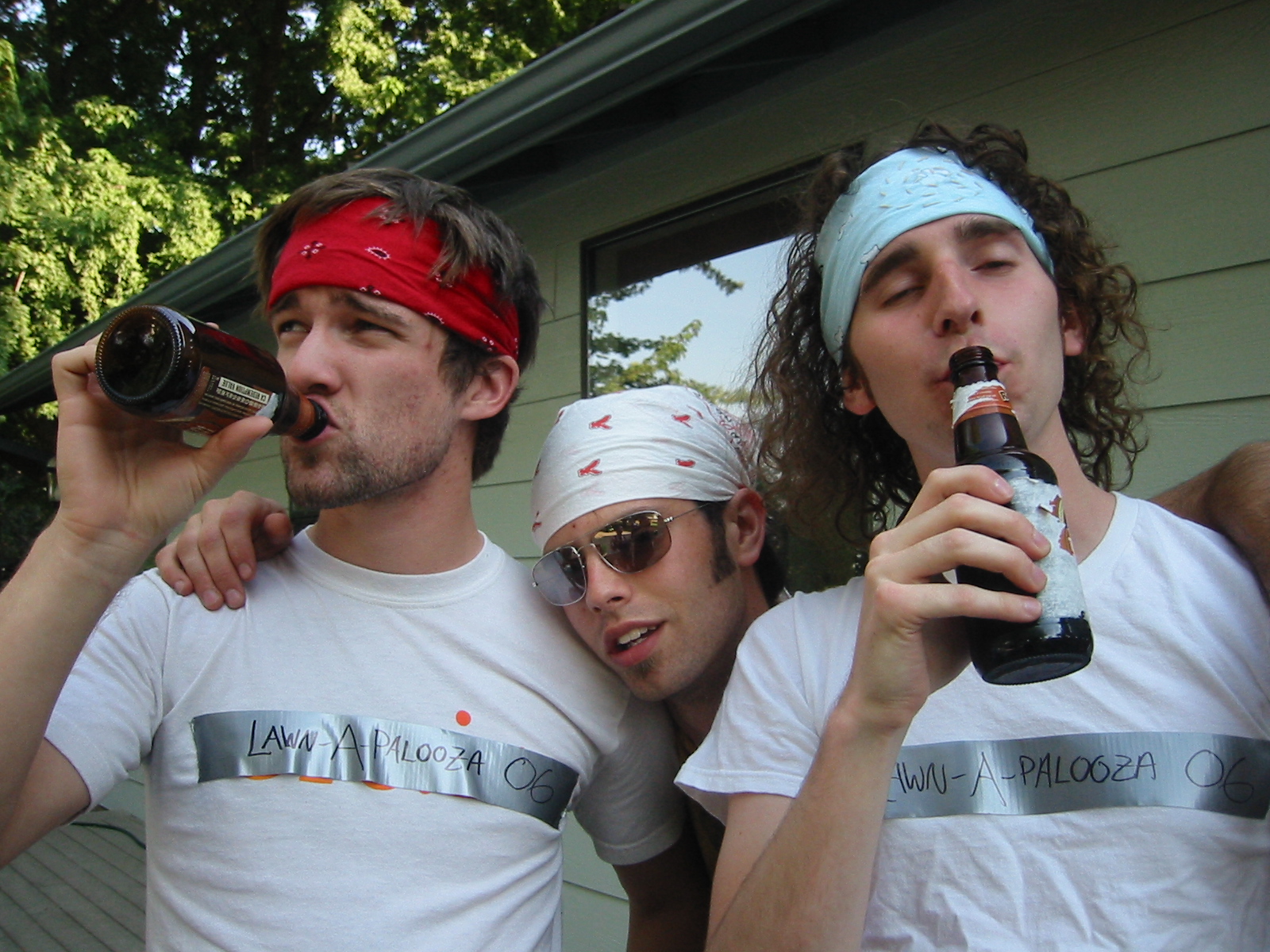 four men wearing blindfolds and one of them drinking beer